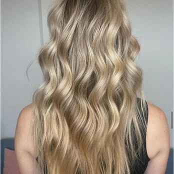 Close-up of warm blonde waves, a Salon Joy guest's finished look