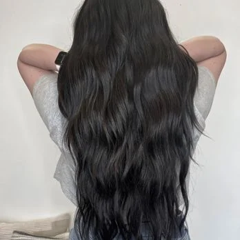 Close-up of long dark brunette waves, a Salon Joy guest's finished look