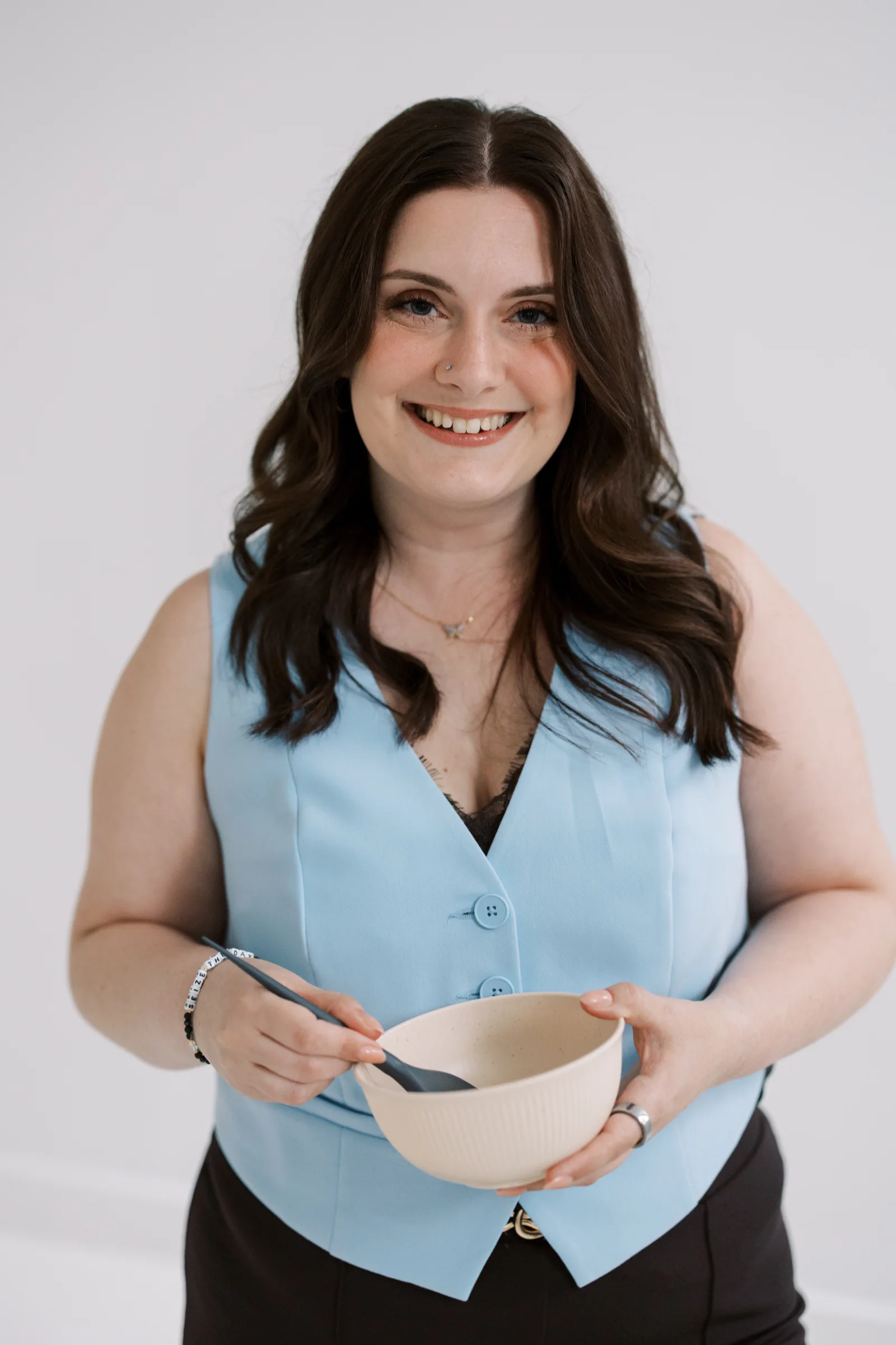 A Salon Joy stylist smiling while mixing color
