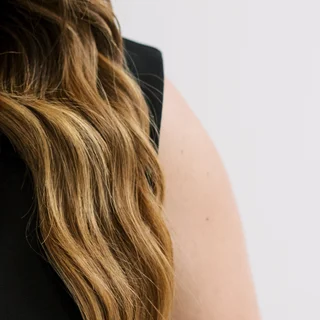 Long, wavy, dimensionally colored hair by Salon Joy